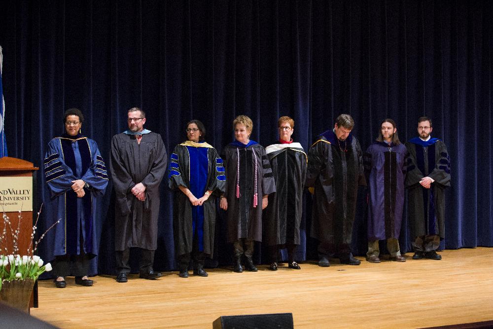 Group of faculty members line up on stage to be honored